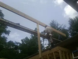 Carpenter setting a ridge beam over a new addition frame — Ice Dam Removal by Roofing Brothers in Silverton